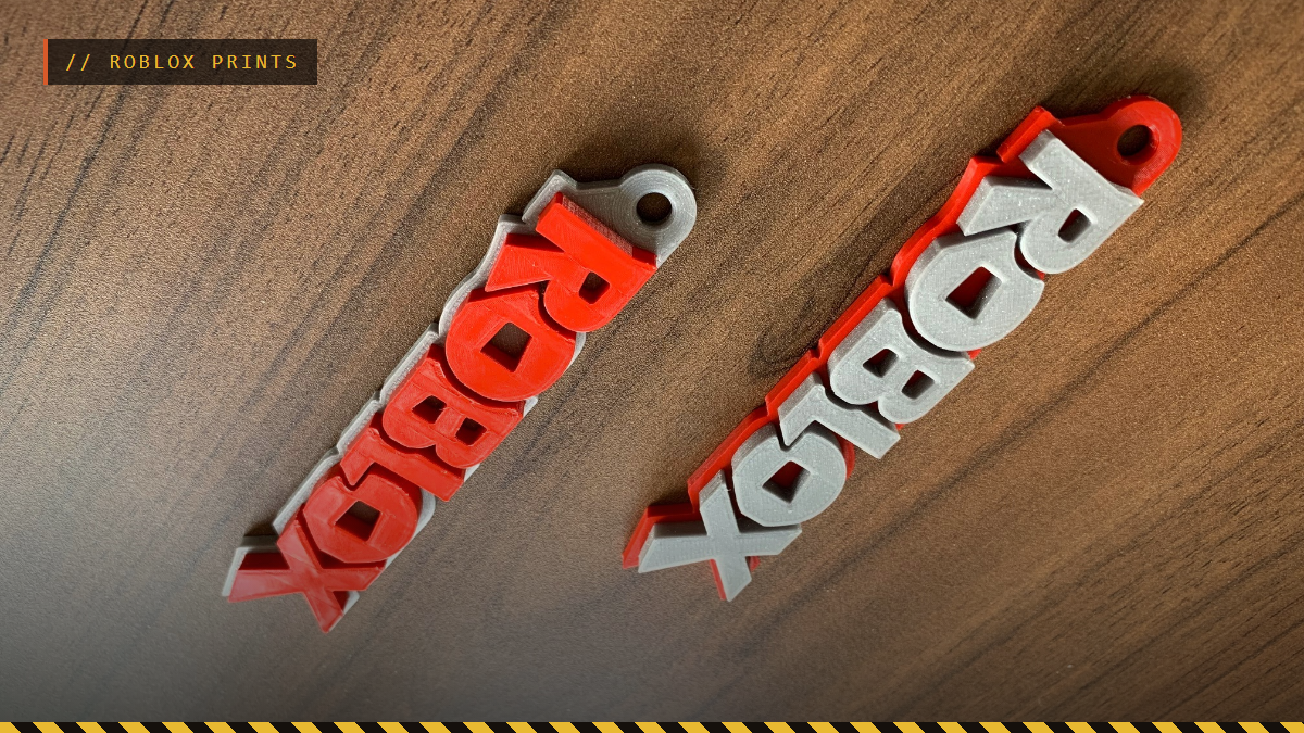 Two 3D printed Roblox logo keychains in red and silver, by n1ck87