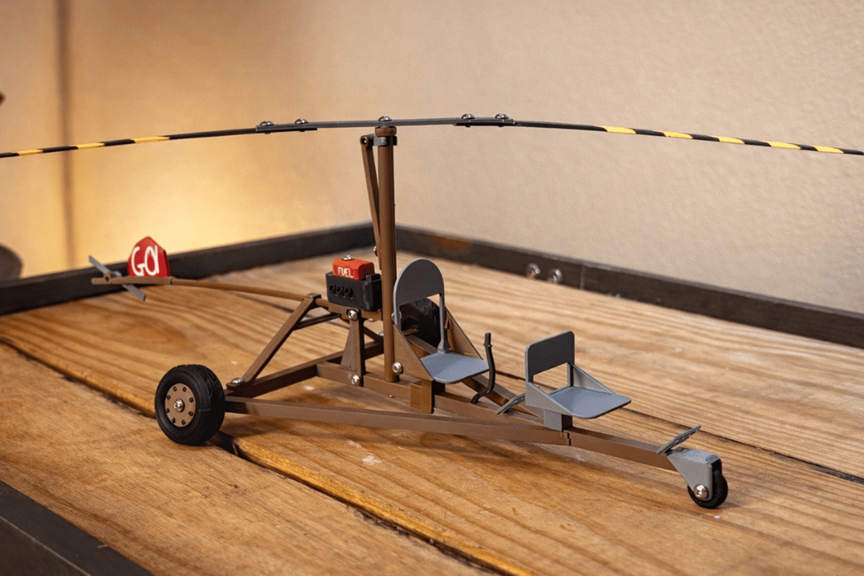 Rust Minicopter DIY build kit assembled on its display stand, a wipe day desk prop