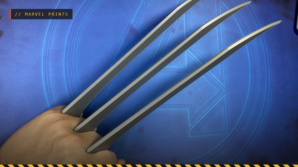 A hand holding 3D printed Wolverine claws, by nerdyviews